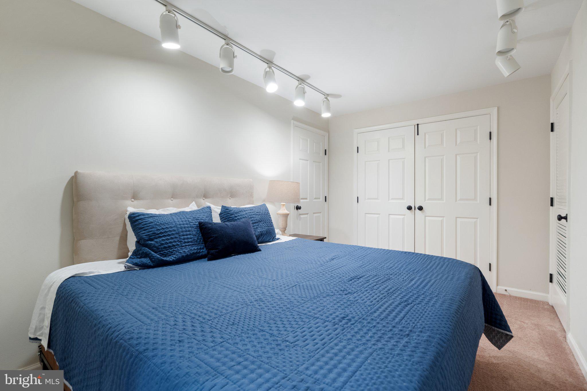 6754 Stapleton Place Gainesville, VA 20155 - Photo 29 of 39 a bedroom with a large bed and a chandelier