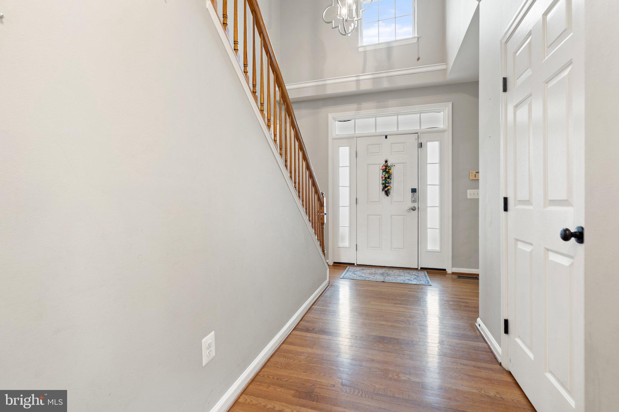 6754 Stapleton Place Gainesville, VA 20155 - Photo 6 of 39 a view of a hallway with wooden floor and staircase