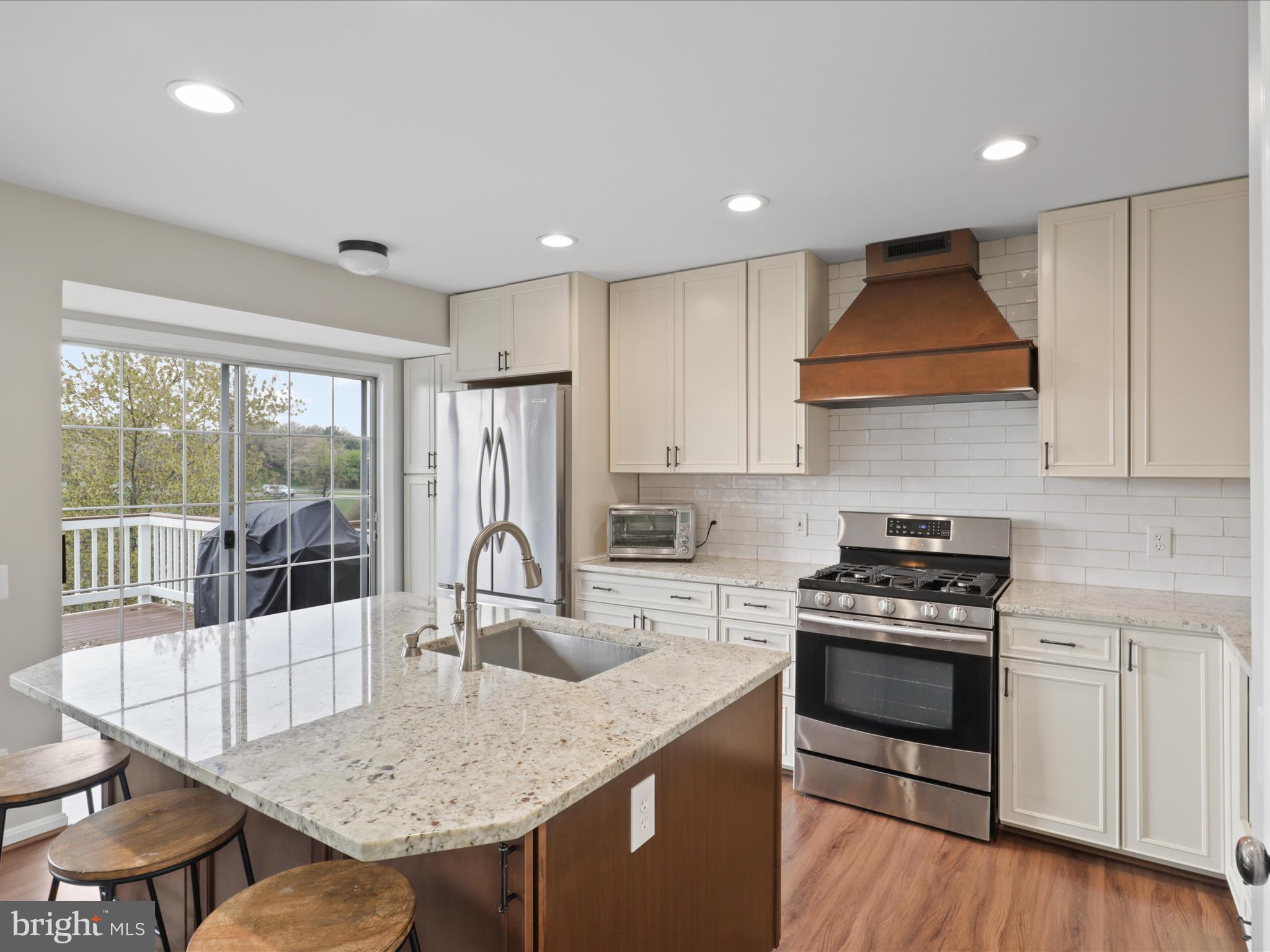 43271 Chokeberry Square Ashburn, VA 20147 - Photo 13 of 45 a kitchen with granite countertop a stove a sink a refrigerator and wooden cabinets