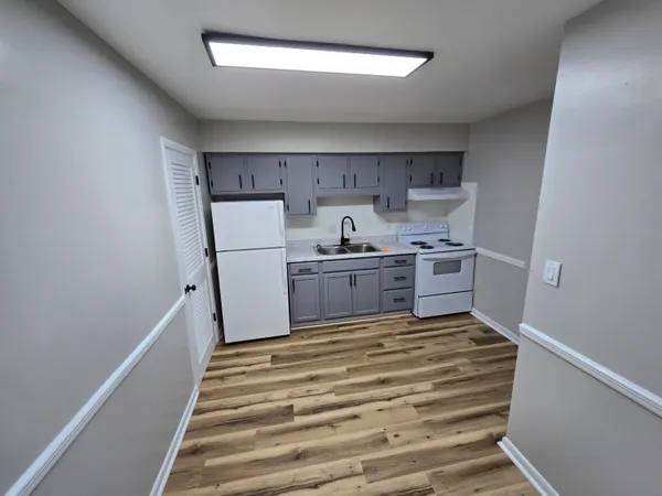 a kitchen with a refrigerator and white cabinets