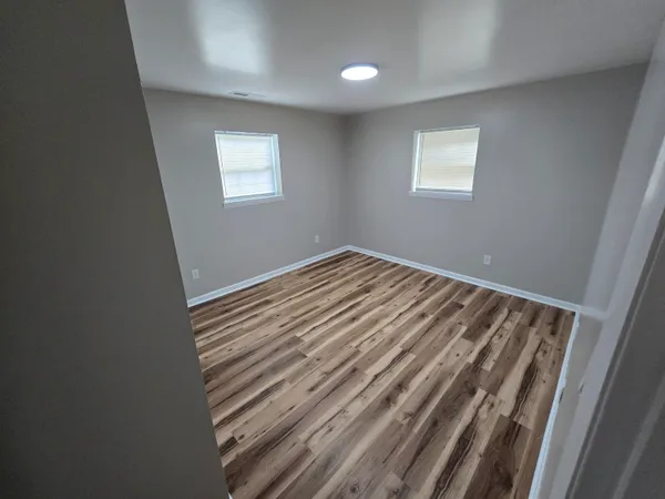 a view of a room with wooden floor and window