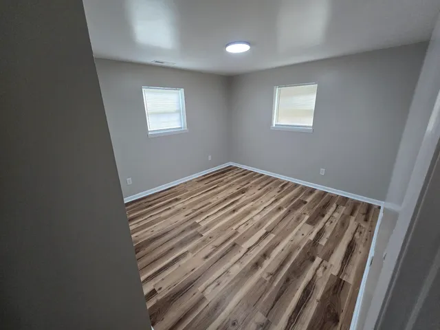 a view of a room with wooden floor and window