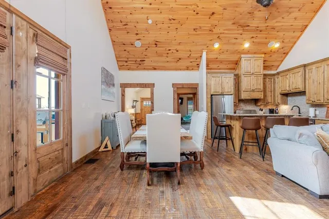 a kitchen with stainless steel appliances granite countertop a stove a sink dishwasher and a refrigerator with wooden floor