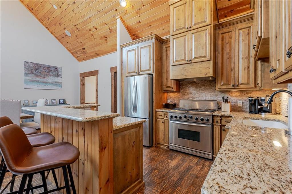 2034 Harbor Way, Unit 601 Graford, TX 76449 - Photo 12 of 27 a kitchen with stainless steel appliances granite countertop a stove a sink dishwasher and a refrigerator with wooden floor
