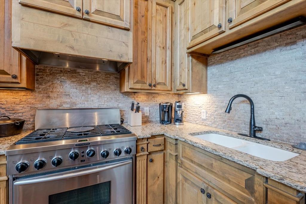 2034 Harbor Way, Unit 601 Graford, TX 76449 - Photo 14 of 27 a kitchen with granite countertop a stove and a sink