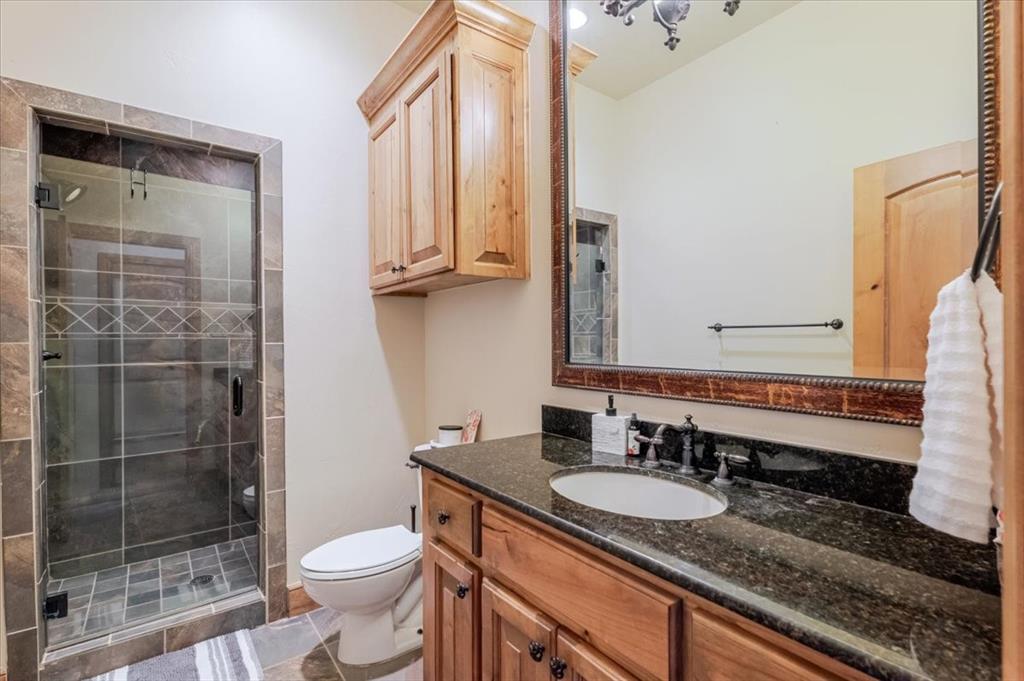 2034 Harbor Way, Unit 601 Graford, TX 76449 - Photo 20 of 27 a bathroom with a granite countertop sink toilet and shower