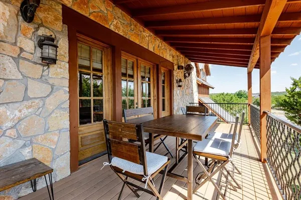 a balcony with couple of chairs and wooden floor