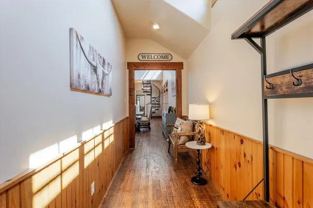 a view of a hallway with wooden floor and staircase