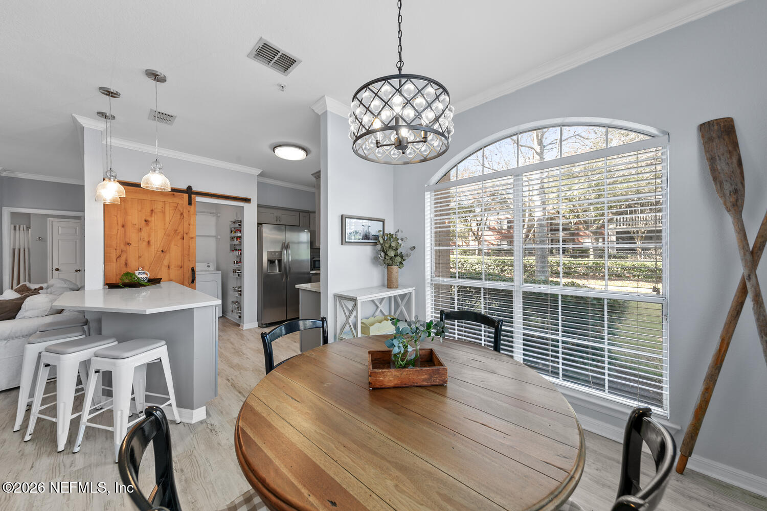 10961 Burnt Mill Road, Unit 317 Jacksonville, FL 32256 - Photo 14 of 39 a dining room with wooden floor a chandelier a wooden table and chairs
