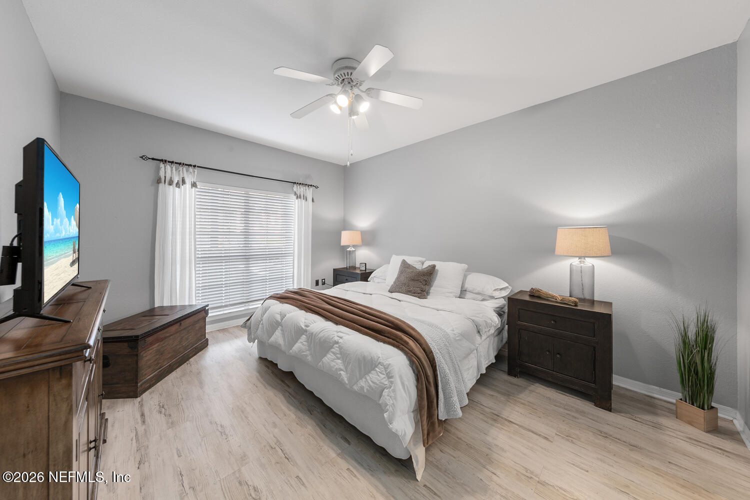 10961 Burnt Mill Road, Unit 317 Jacksonville, FL 32256 - Photo 16 of 39 a bedroom with a bed and a flat tv screen on dresser