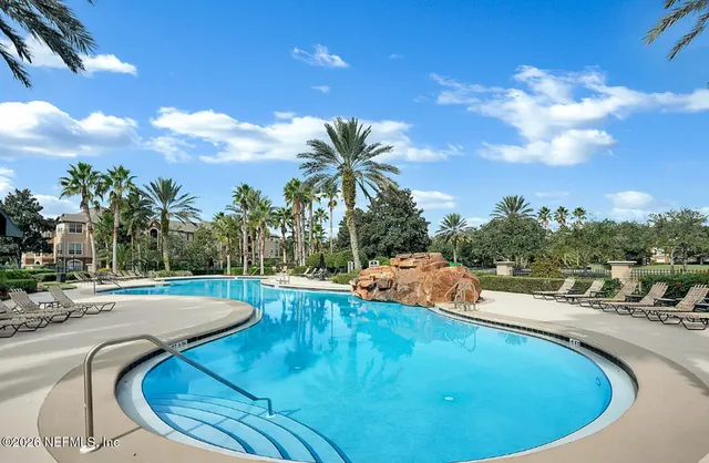 a view of a house with backyard and tree