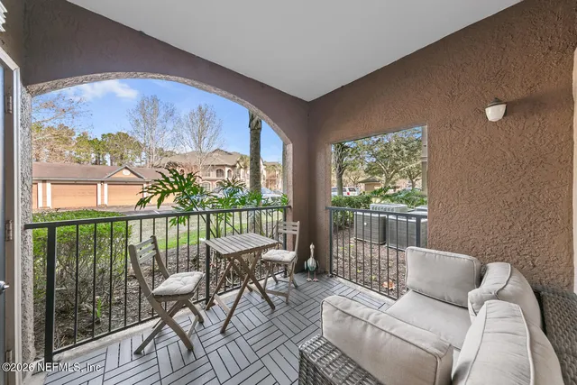 a balcony with furniture and a potted plant