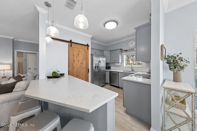 a kitchen with a sink a refrigerator and cabinets