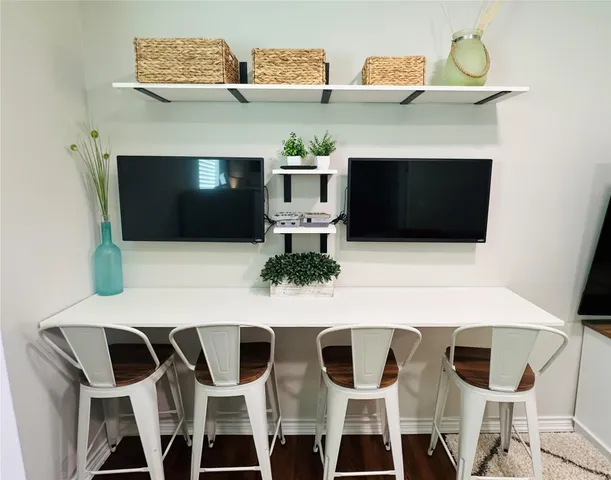 a living room with a fireplace a flat screen tv and chairs