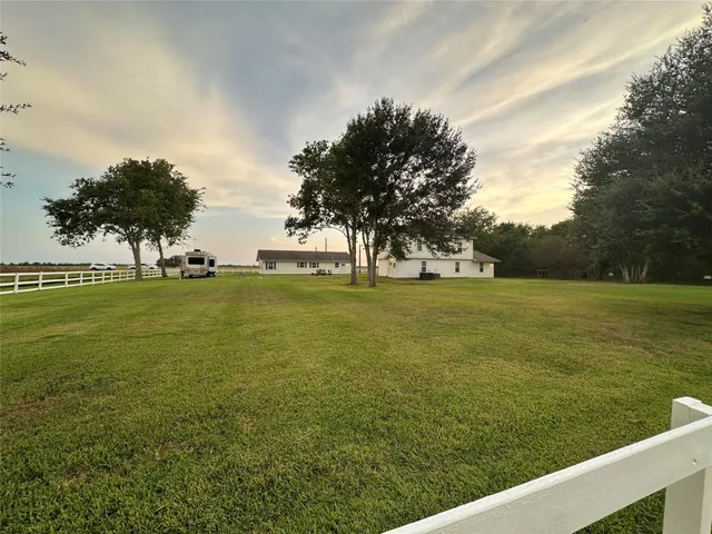 a view of a green field with wooden fence