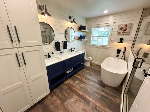 a bathroom with a double vanity sink mirror and tub