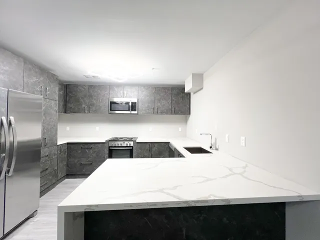 a kitchen with a sink a microwave a refrigerator and cabinets