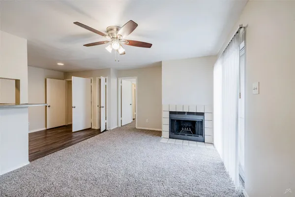 a view of an empty room with a fireplace and a window