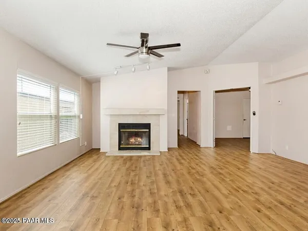 a view of empty room with wooden floor and fireplace