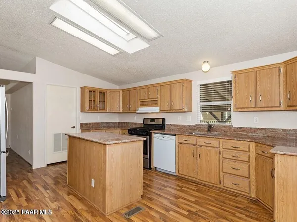 a kitchen with stainless steel appliances granite countertop a stove a sink dishwasher and a refrigerator