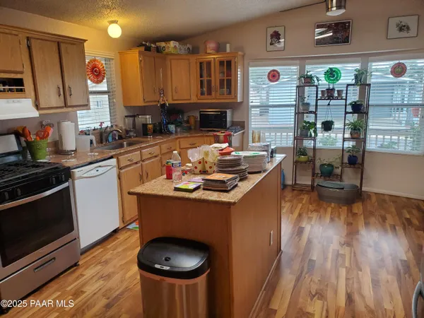 a kitchen with stainless steel appliances granite countertop a sink stove and wooden floor