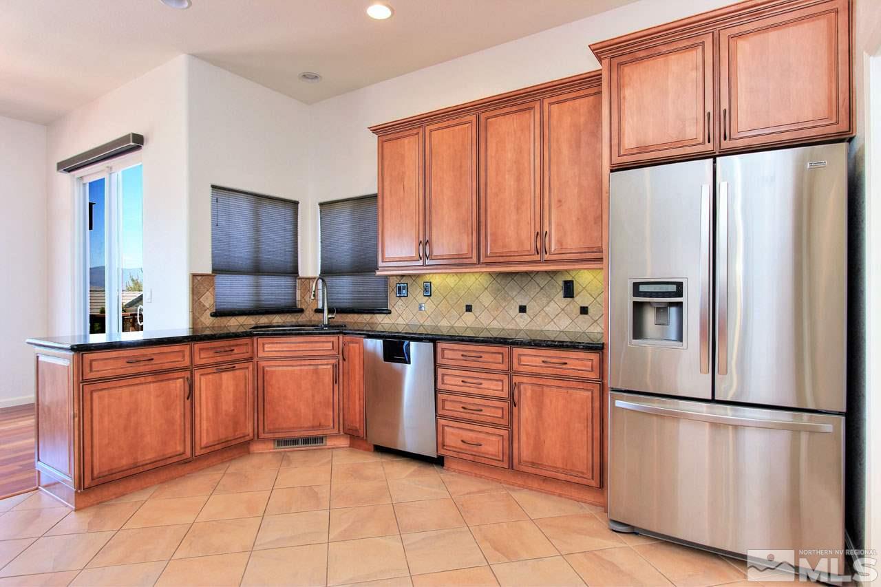 1094 University Ridge Drive Reno, NV 89512 - Photo 7 of 23 a kitchen with stainless steel appliances granite countertop a refrigerator sink and cabinets