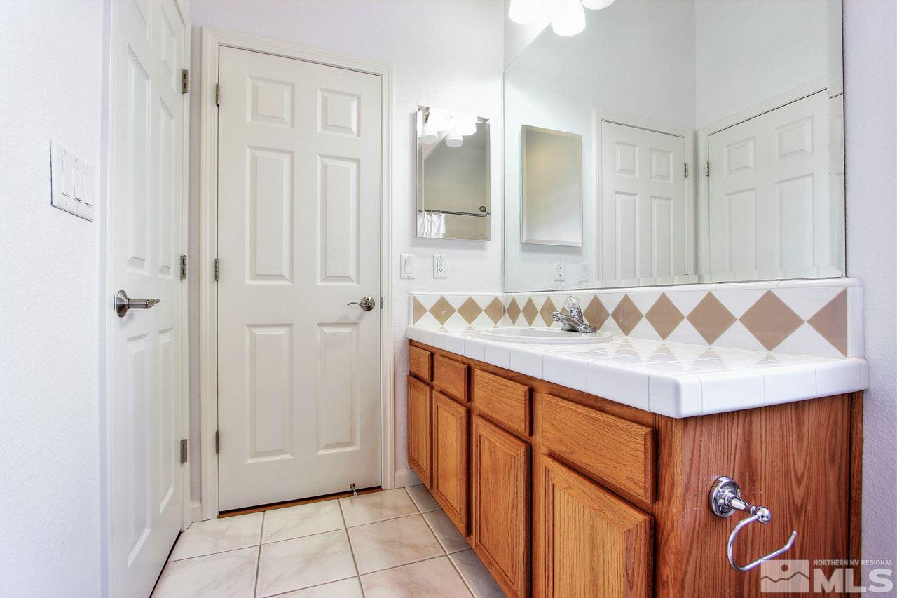 1094 University Ridge Drive Reno, NV 89512 - Photo 9 of 23 a bathroom with a sink and a mirror