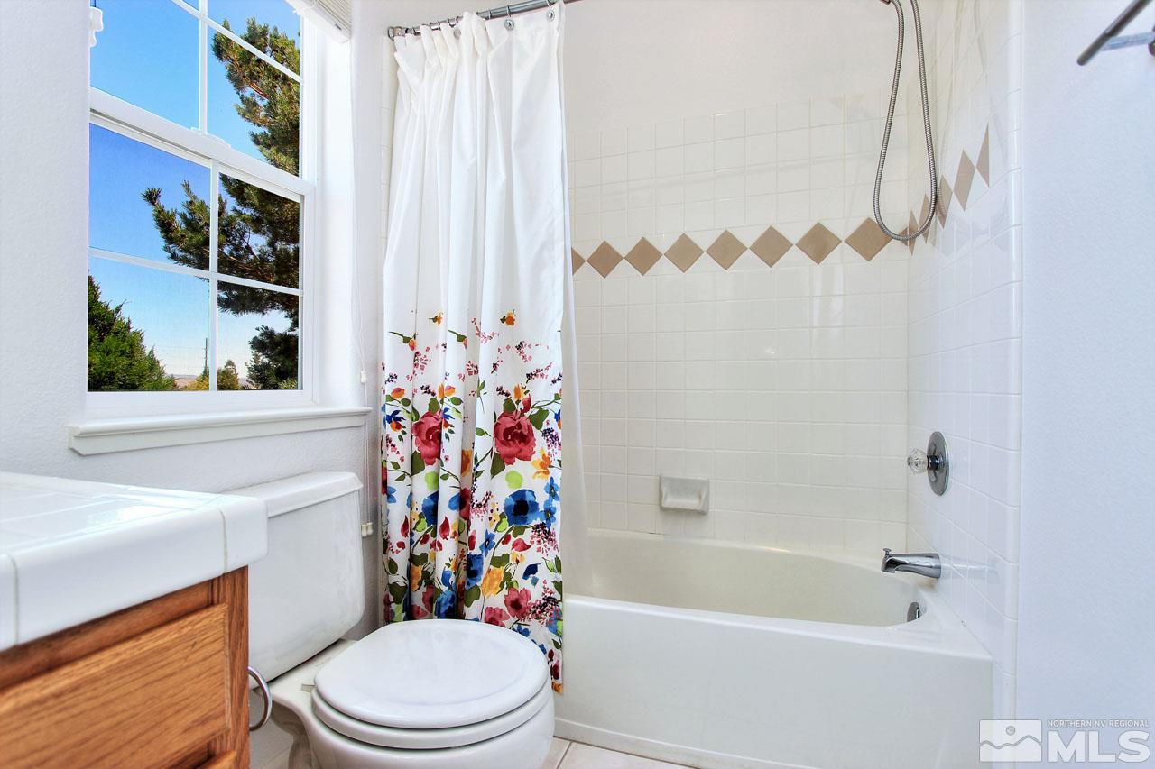 1094 University Ridge Drive Reno, NV 89512 - Photo 10 of 23 a white toilet sitting next to a bath tub