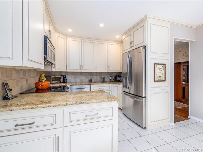 16 Wright Road Rockville Centre, NY 11570 - Photo 6 of 23 a kitchen with a refrigerator sink and cabinets