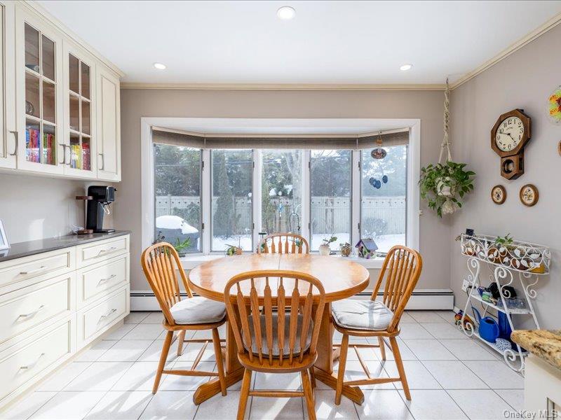 16 Wright Road Rockville Centre, NY 11570 - Photo 7 of 23 a dining room with furniture a rug and a floor to ceiling window