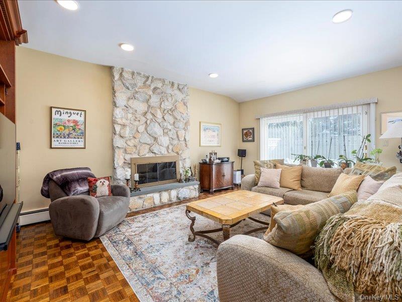 16 Wright Road Rockville Centre, NY 11570 - Photo 9 of 23 a living room with furniture a fireplace and a flat screen tv