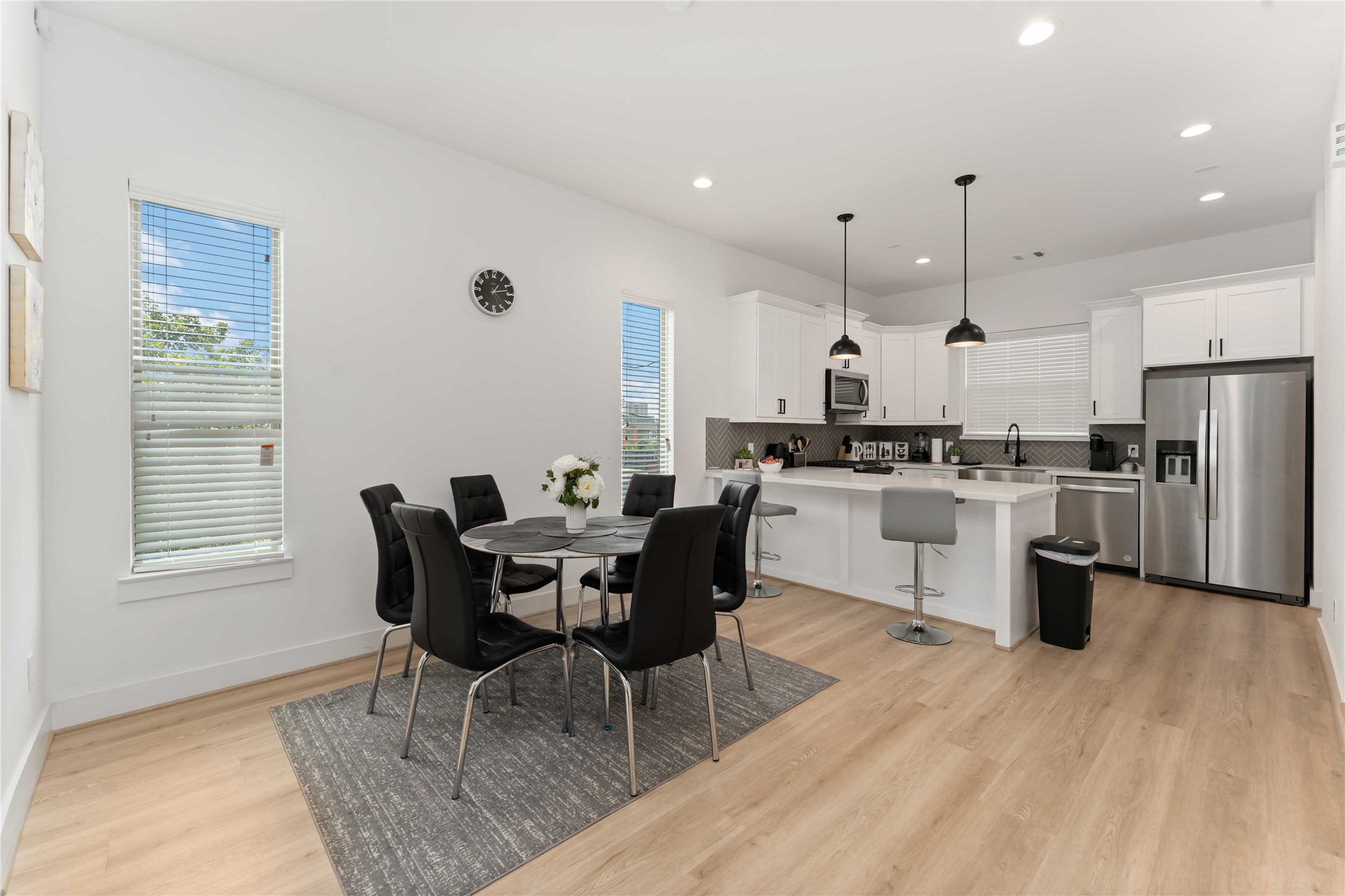 a kitchen with stainless steel appliances granite countertop a stove a sink a dining table and chairs