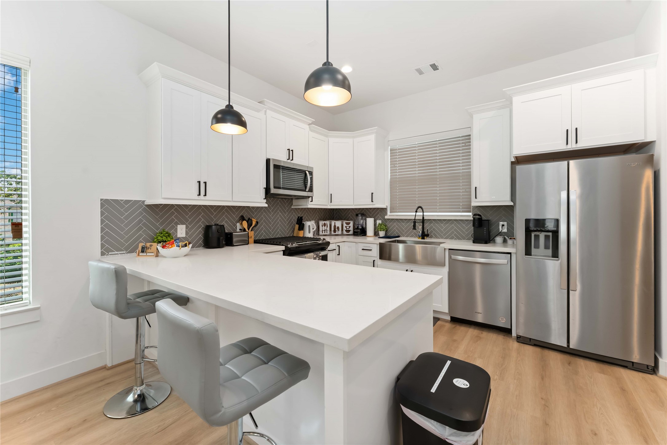 2341 Eagle Street Houston, TX 77004 - Photo 14 of 30 a kitchen with kitchen island a stove a sink a refrigerator and chairs with wooden floor