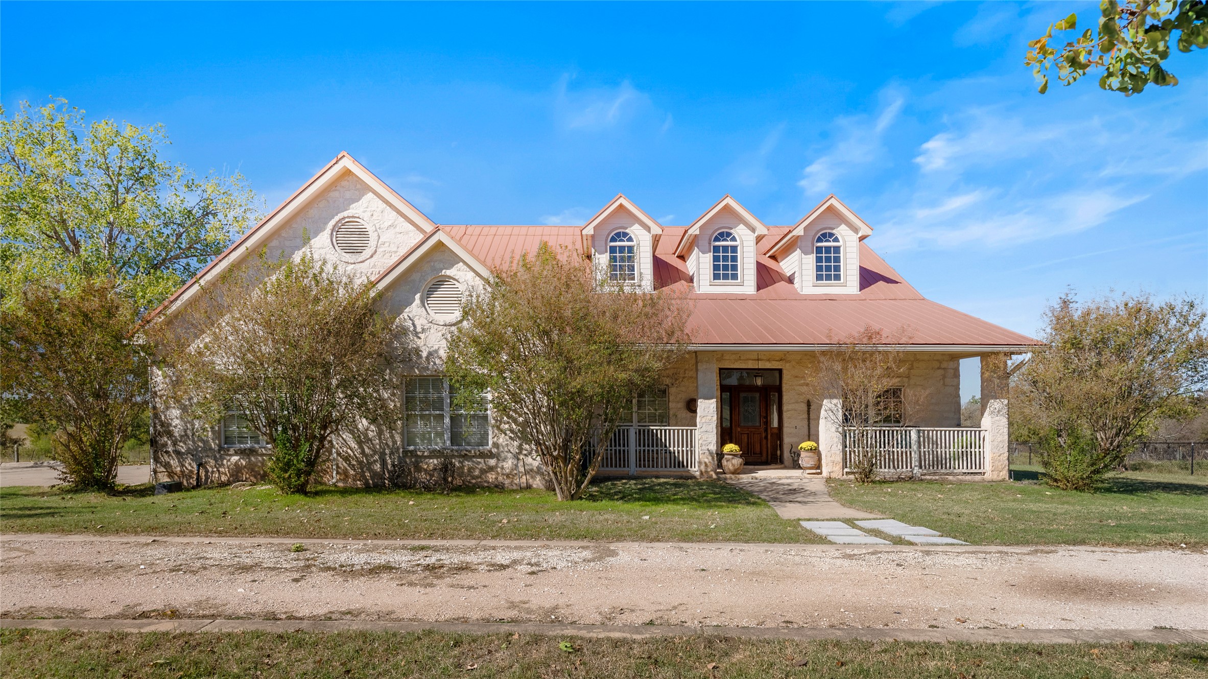 View of front facade featuring a metal roof, covered porch, and a front lawn