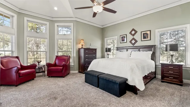 a spacious en suite bathroom with a double vanity sink a toilet a mirror and shower