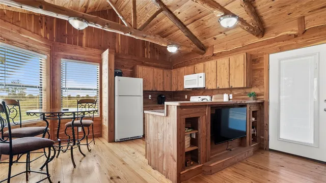 a kitchen with stainless steel appliances granite countertop a sink dishwasher and a stove with wooden floor
