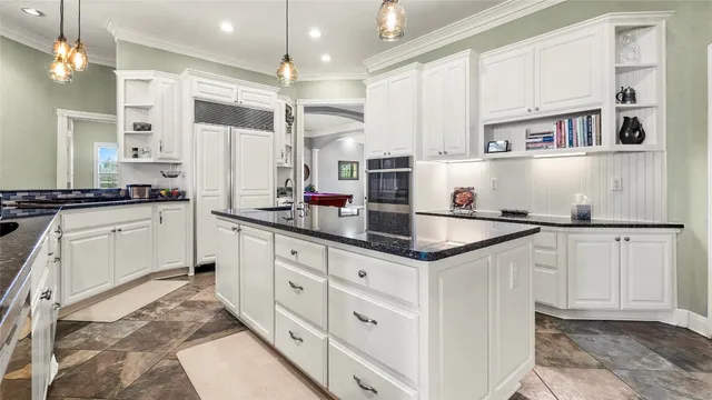 a kitchen with stainless steel appliances granite countertop a sink a stove and a counter space