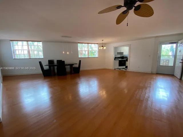 a view of empty room with wooden floor and windows
