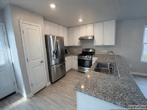 a kitchen with a sink a refrigerator a stove a microwave and cabinets