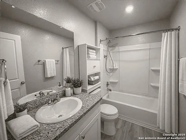 a bathroom with a granite countertop sink toilet and shower