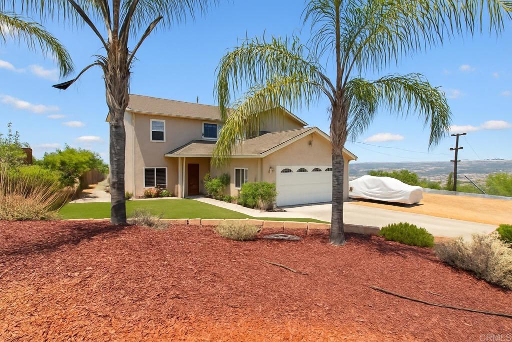 a view of a house with a yard and palm trees