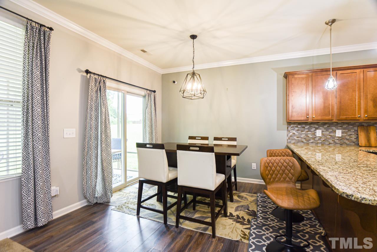 3644 Tule Spring Street Raleigh, NC 27610 - Photo 5 of 18 a dining room with granite countertop furniture and a chandelier