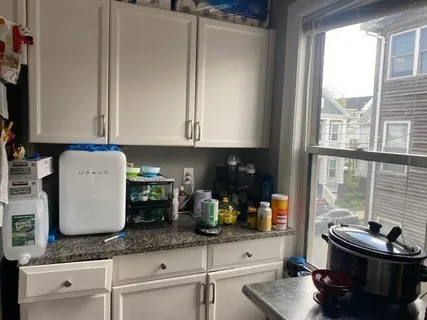 a kitchen with granite countertop white cabinets and stainless steel appliances