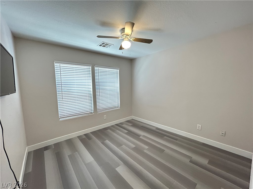 6538 Elm Spring Las Vegas, NV 89148 - Photo 21 of 29 A well-lit bedroom features sturdy laminate flooring and a comforting ceiling fan for year-round comfort.