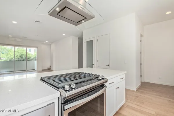 a kitchen with a stove and a wooden floor