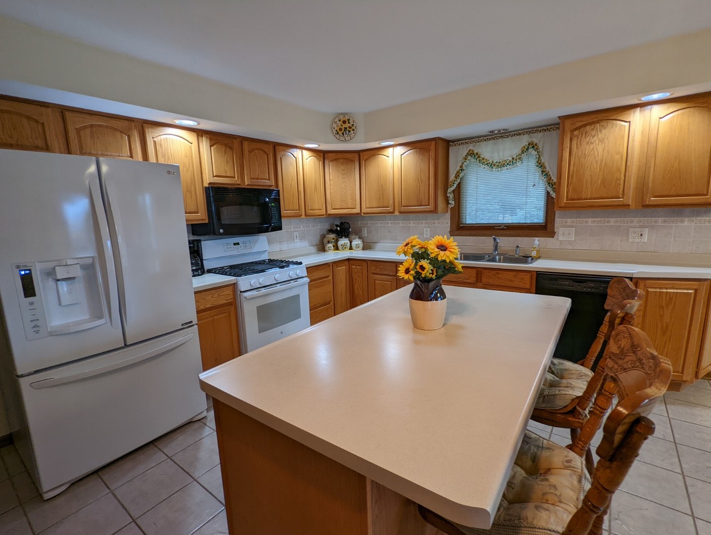 8597 East Winneshiek Road Ridott, IL 61067 - Photo 17 of 49 a kitchen with stainless steel appliances a refrigerator a sink a stove a dining table and chairs