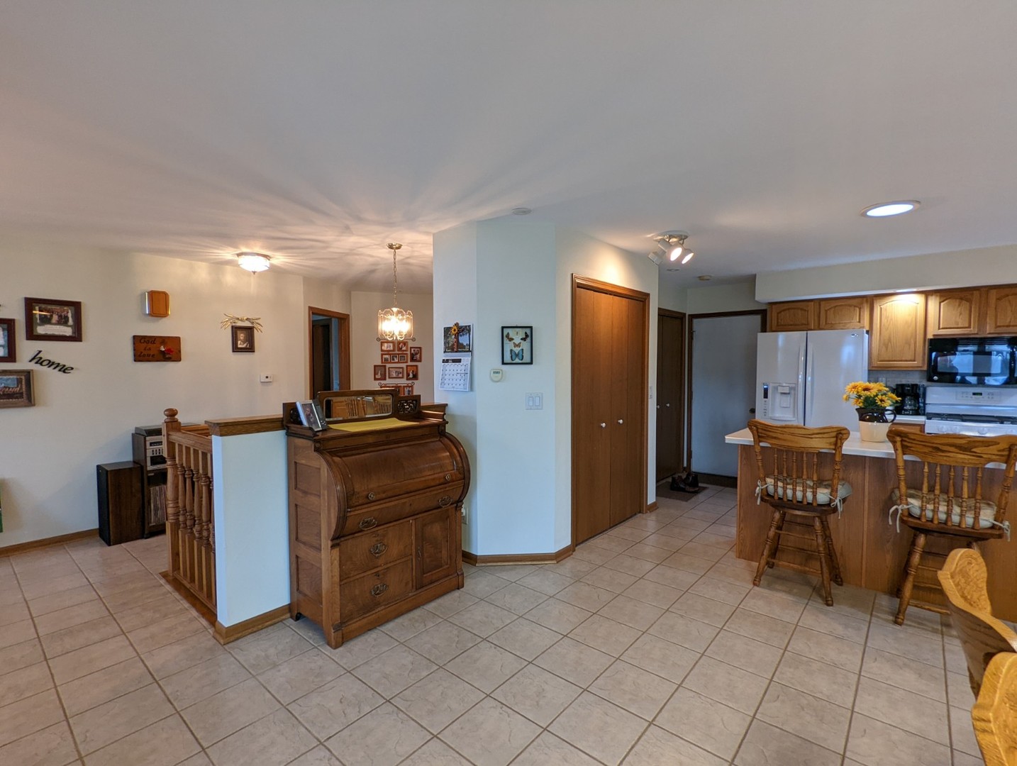 8597 East Winneshiek Road Ridott, IL 61067 - Photo 36 of 49 a kitchen with stainless steel appliances kitchen island granite countertop a refrigerator a stove a microwave oven with white cabinets and couches