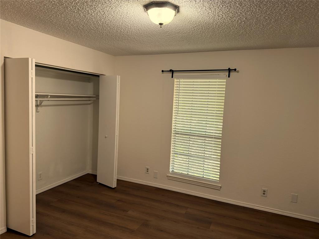 18240 Midway Road, Unit 206 Dallas, TX 75287 - Photo 13 of 16 Room featuring wood-finish flooring, a window with blinds, a bi-fold closet, and a ceiling-mounted light fixture