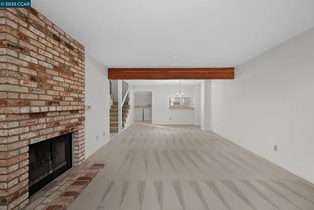 a view of empty room with wooden floor and fireplace