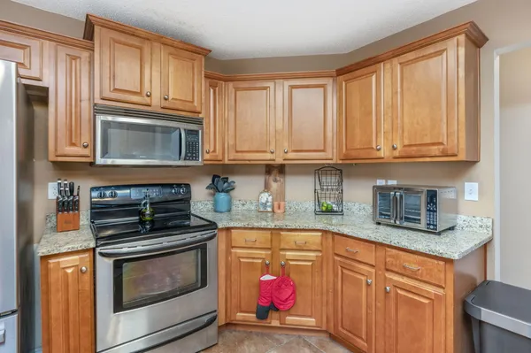 a kitchen with granite countertop cabinets stainless steel appliances and a sink